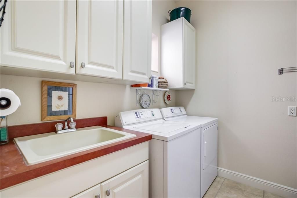 Laundry room with storage & extra fridge.