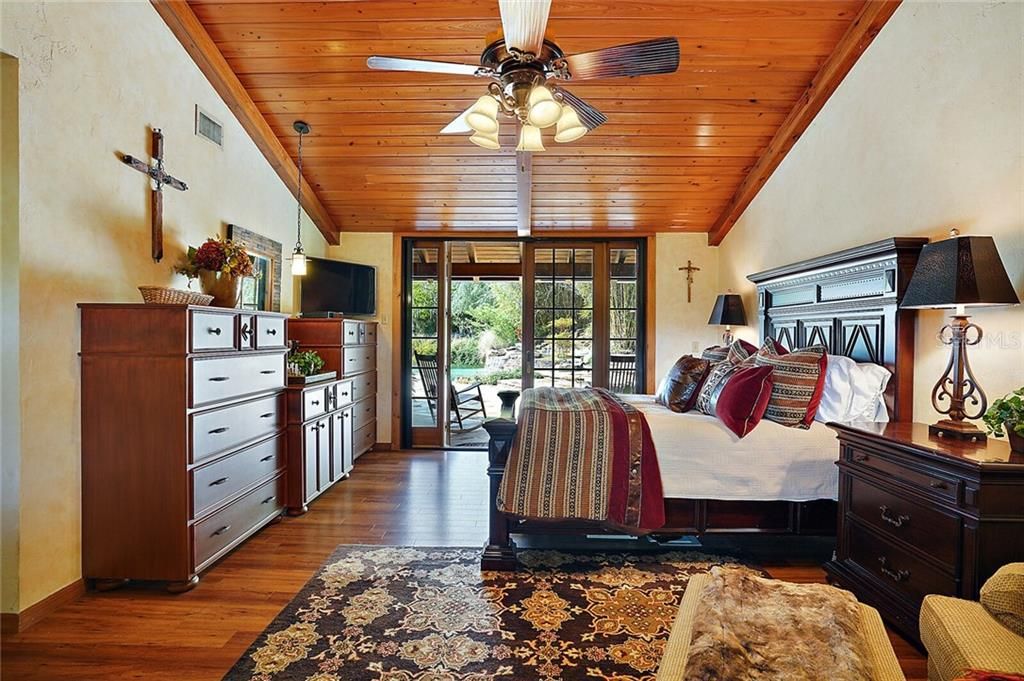 Master Bedroom with Wood Ceiling and French Doors Leading to the Pool and Spa