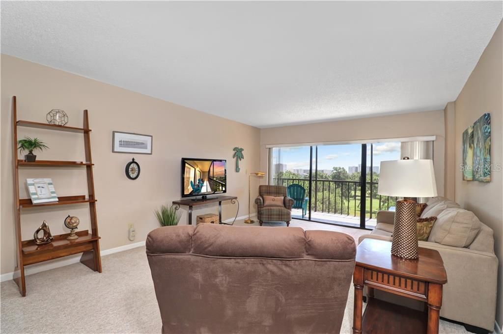 Living area with sliding doors allowing direct access to the lanai. Beautiful view overlooking the golf course.