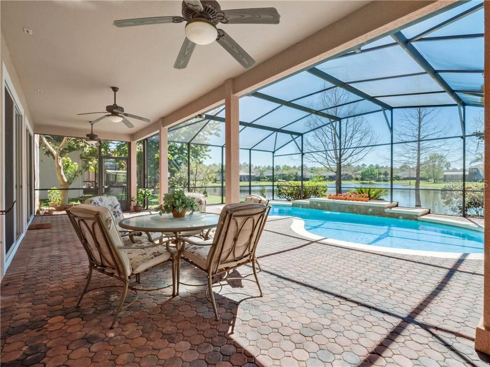 Screen enclosed outdoor living area with pool and pond views