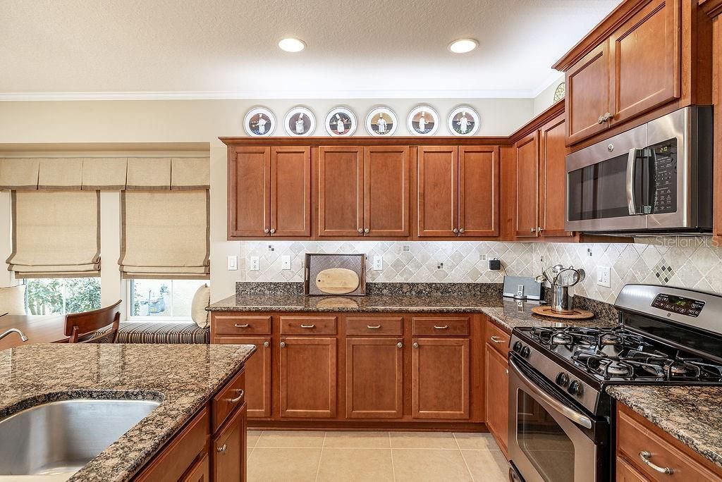 Kitchen with granite countertops and tile backsplash and window seat.