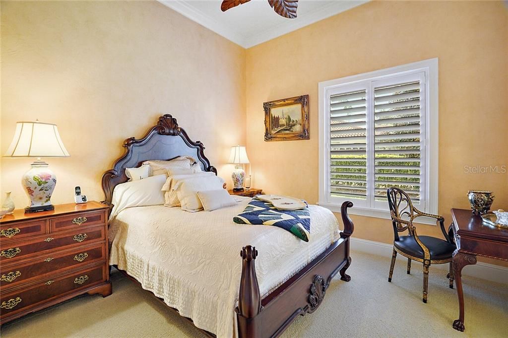 Guest bedroom with ceiling fan, carpeted flooring and crown molding