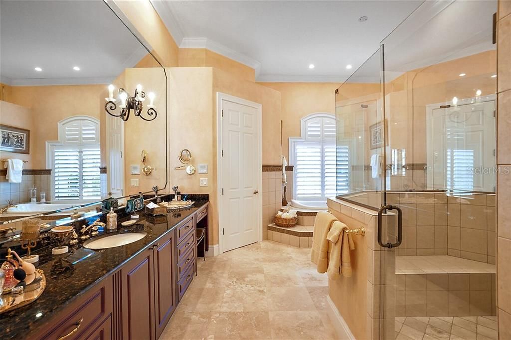 Spa-worthy en-suite with dual granite sink vanities, double walk-in closets, jetted soaking tub, and walk-in shower with multiple sprayer jets.