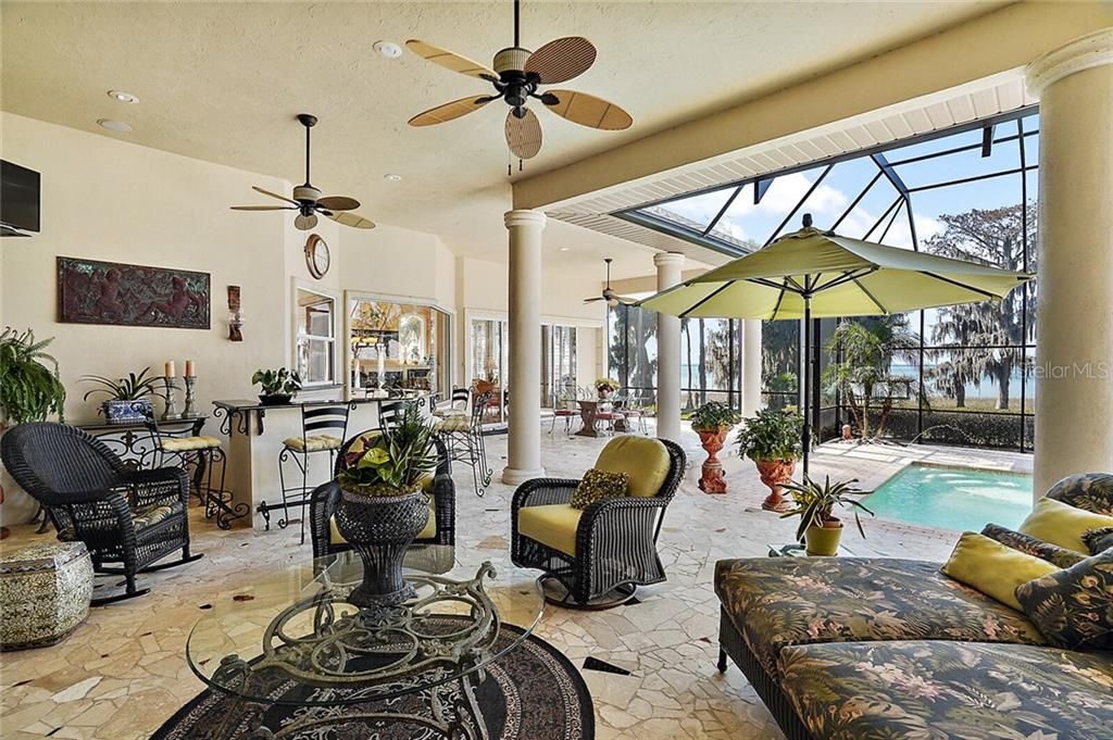 A fully screened lanai offers unparalleled lake views, plus a wet bar and covered areas for entertaining large groups by the fireplace.