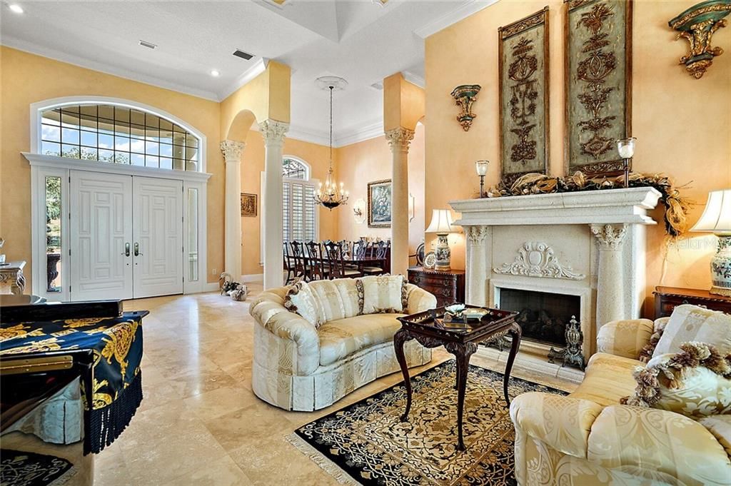 This luxury home features a palatial interior with soaring 17-foot custom-trimmed tray ceilings, wide crown molding, and baseboards, custom-fit Plantation shutters, Travertine floors, artist murals and paint finishes, cast stone columns and fireplaces, locally crafted ironwork details, and lighted art niches.