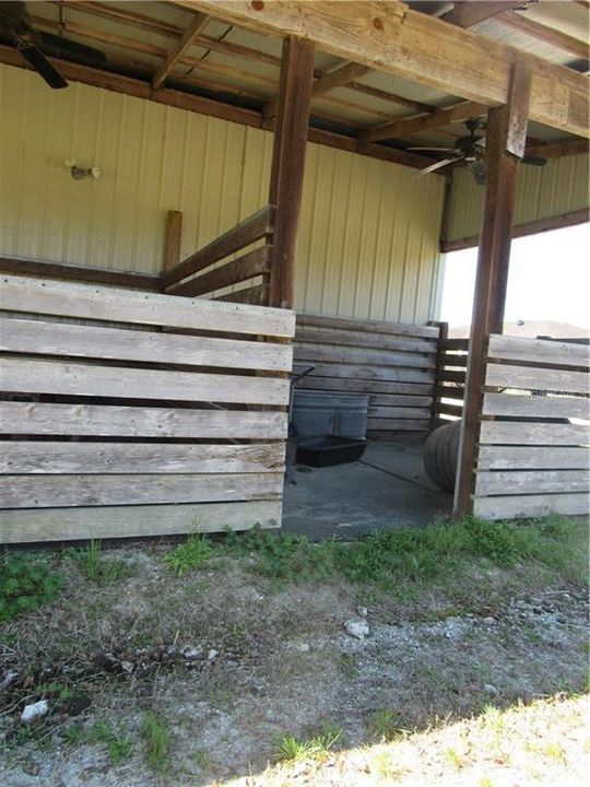 Two individual horse stalls outside with fans to keep them cool and bug free.