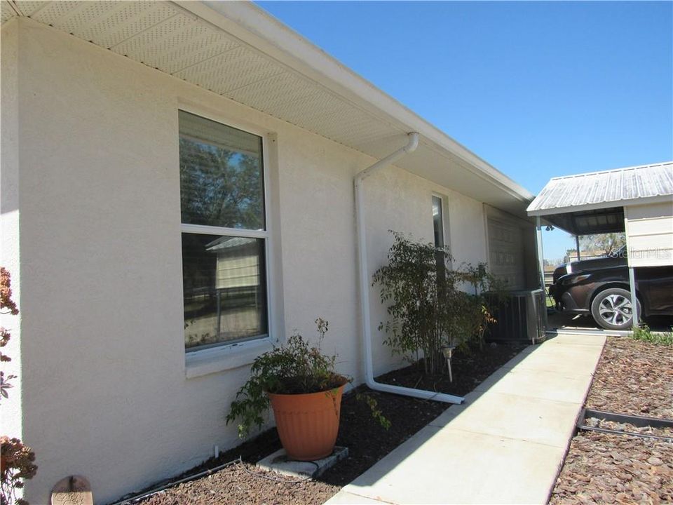 The driveway side of the house is nicely landscaped and the carport is conveniently placed.