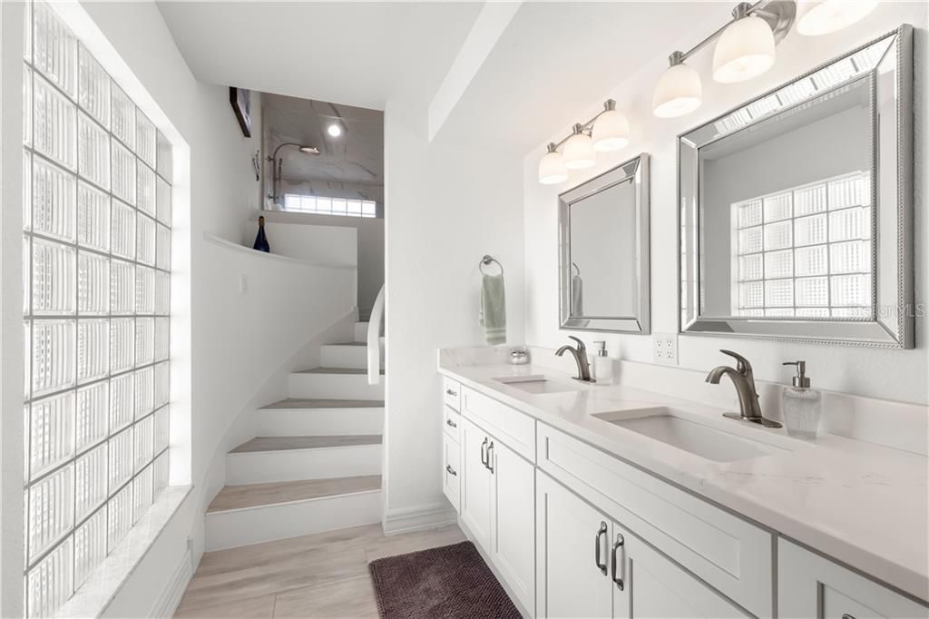 Completely remodeled master bath with modern finishes such as white shaker cabinetry and quartz countertops.