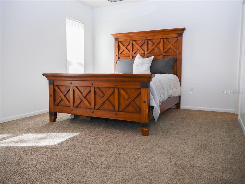Spacious master bedroom with comfy carpet flooring.