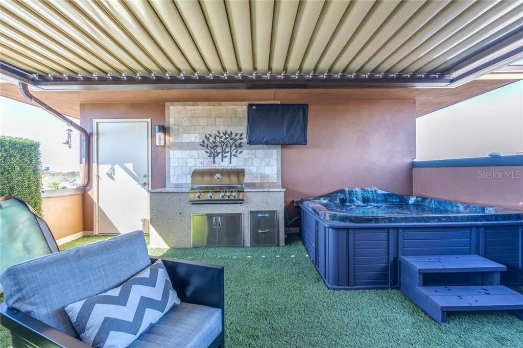Covered Rooftop Terrace features a gas grille and hot tub