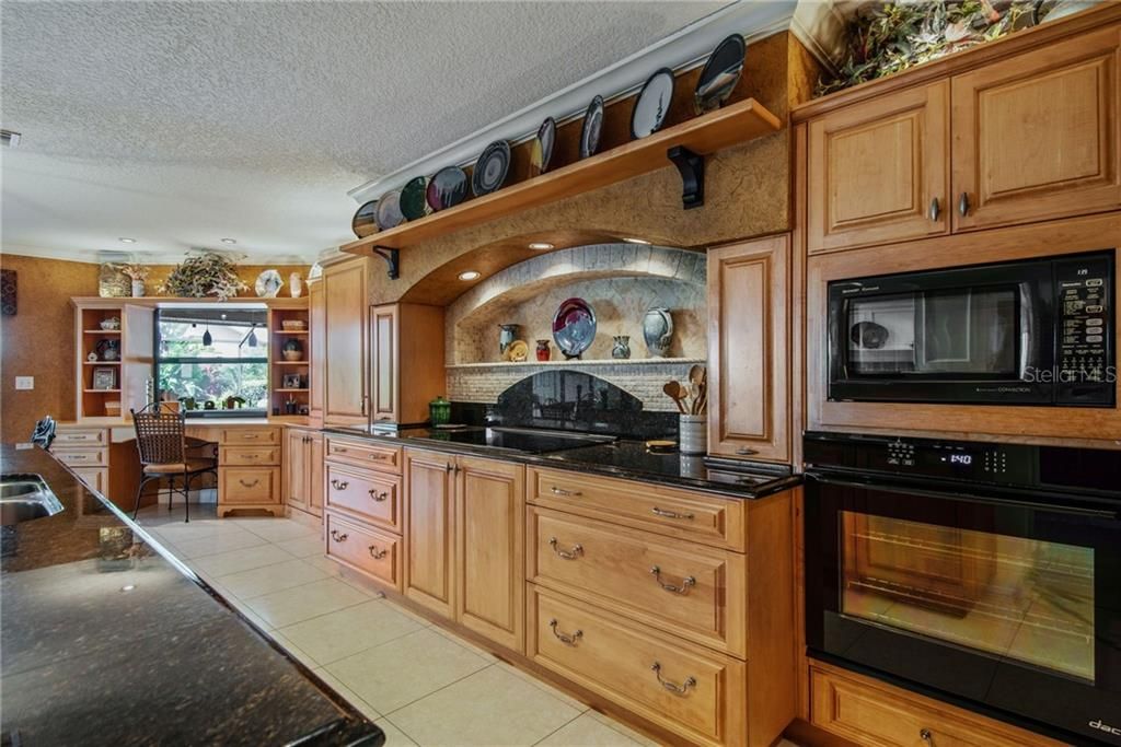 Custom kitchen w/stovetop, microwave & wall oven.  Desk area with additional storage.