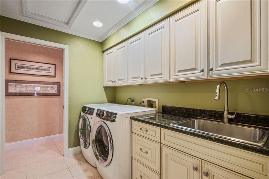 Large walk through laundry room with additional cabinets for storage!