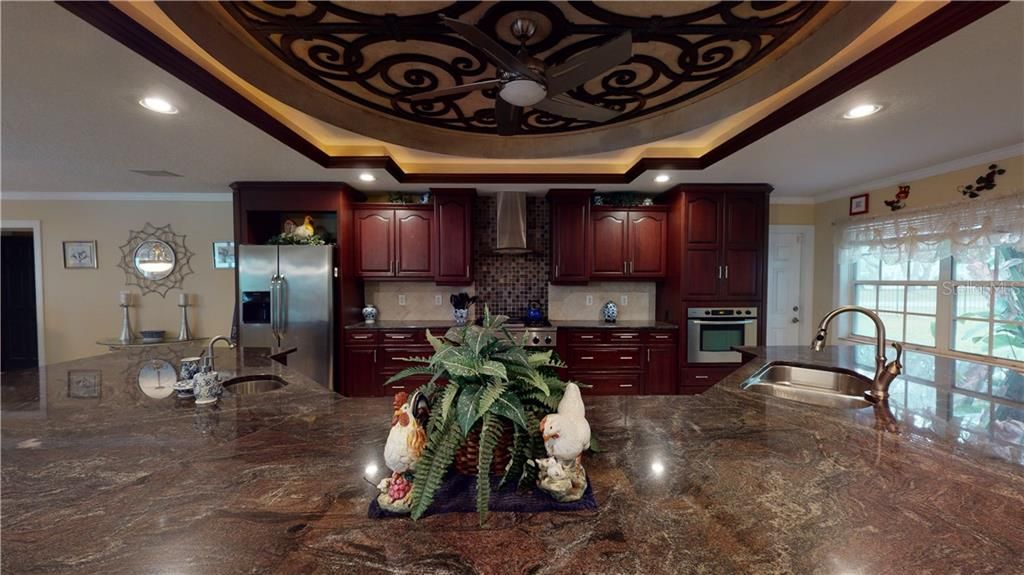 Massive granite breakfast bar with dual sinks.  And check out that custom lit ceiling!