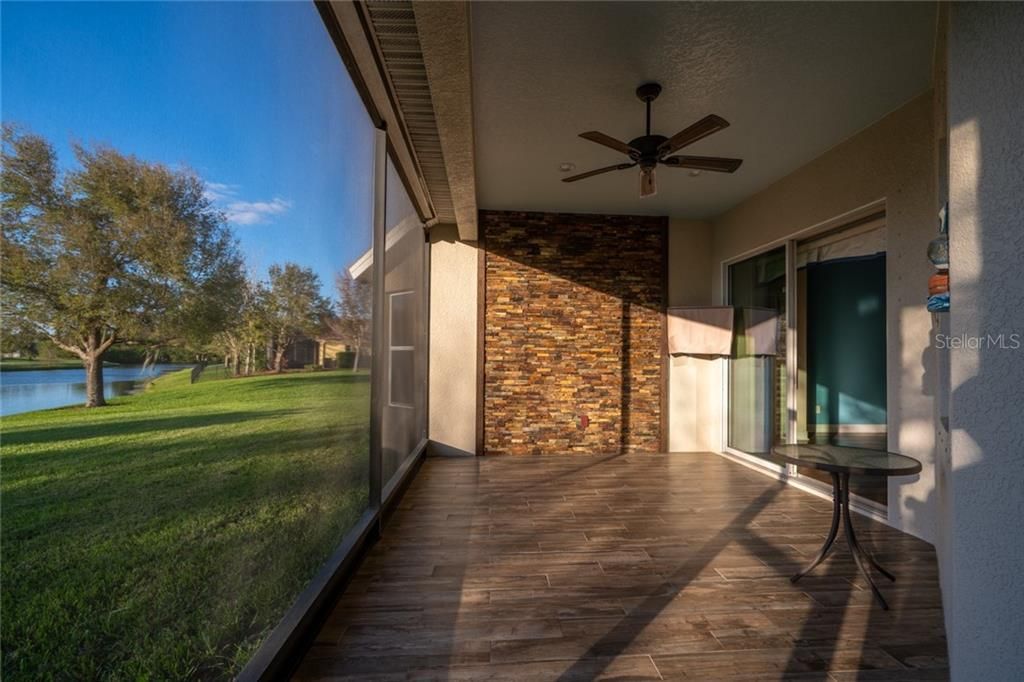 SCREENEN IN LANAI OFFERS TILE FLOORING & LEDGER STONE ACCENT WALL