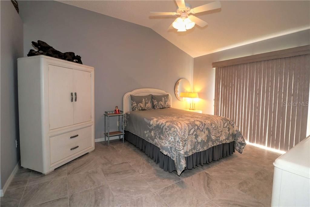 Master bedroom has beautiful tiled floor, vaulted ceiling and sliders out to back yard.