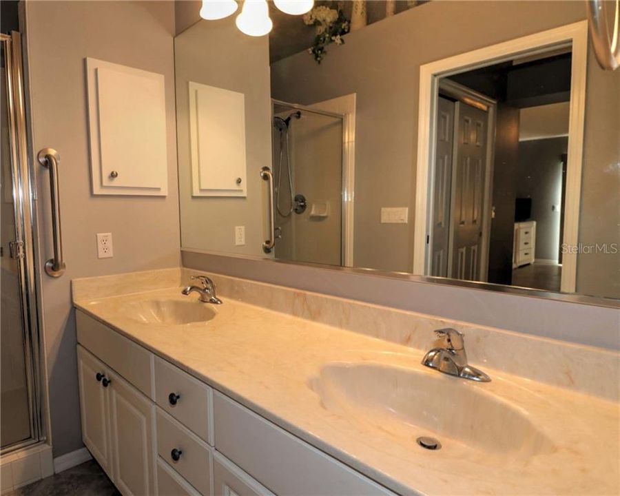 Master bath has double sinks of cultured marble, new fixxtures, glassed in tile shower with seat and grab bars.