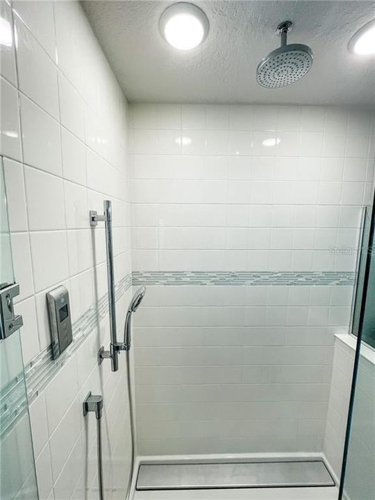 Walk in shower with listello and tile to ceiling plus 2 shower heads with digital control system for water temperature