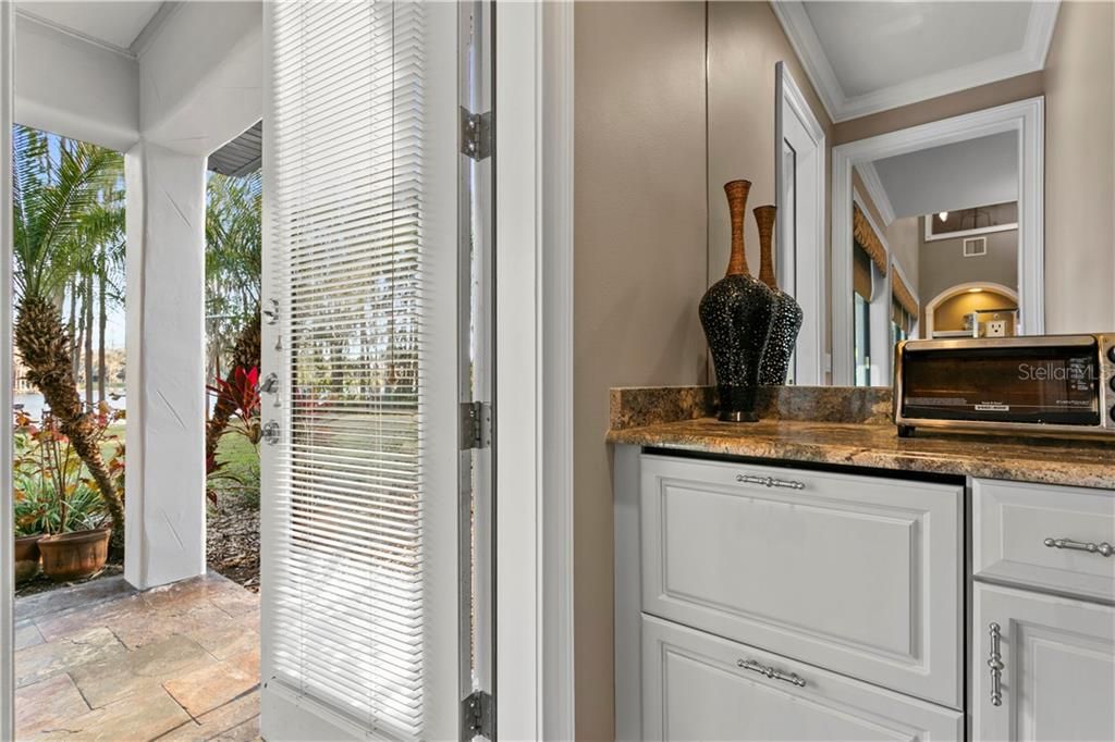 French door to the lanai, with two drawer ULine beverage refrigerator positioned near the patio.