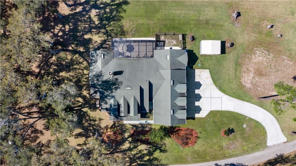 Aerial View of Home, Screened Lanai, Fenced Pet Area, Shed, Driveway and Parking Pad leading into side entrance oversized 3 car garage