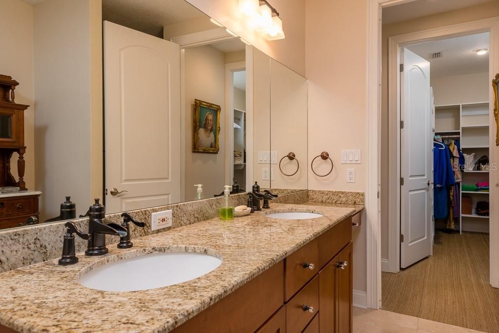 Large master bathroom has double vanities, upgraded walk in jetted shower, linen closet and vanity area. Across the hall is the generously sized master closet with custom built ins.