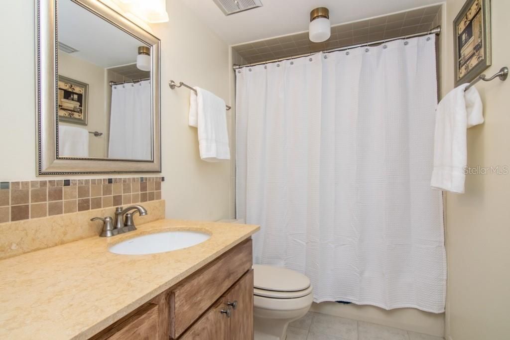 Guest Bathroom with granite countertops includes a tub/shower combination.