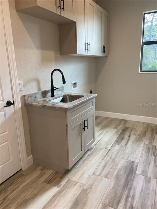 Laundry room with custom cabinetry, granite counter and built-in sink - upgraded spray-foam insulated roof for extra protection as well as insulation value.