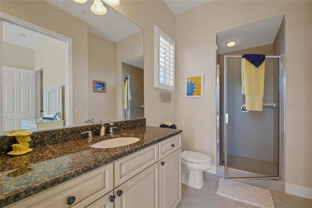 Bedroom 3 ensuites over bathroom view of walk in shower, granite counter and diagonal tile