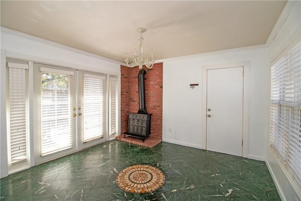 This bonus area could be a family room, office, dining room, kid space, anything! There is beautiful natural light, French doors, and this awesome old wood burning fireplace.