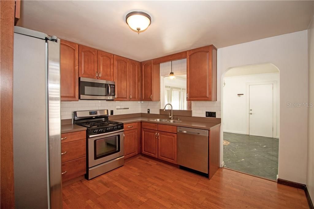 Modern kitchen with new appliances, clean subway tile backsplash, and plenty storage/work space.