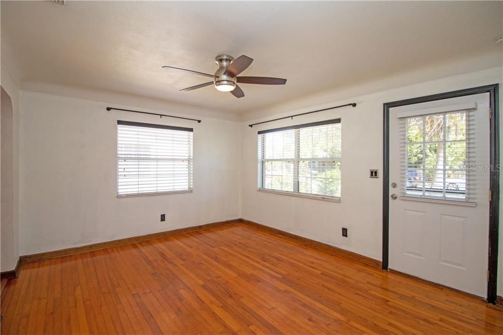Sunny living room with original hardwood floors and coved ceilings.