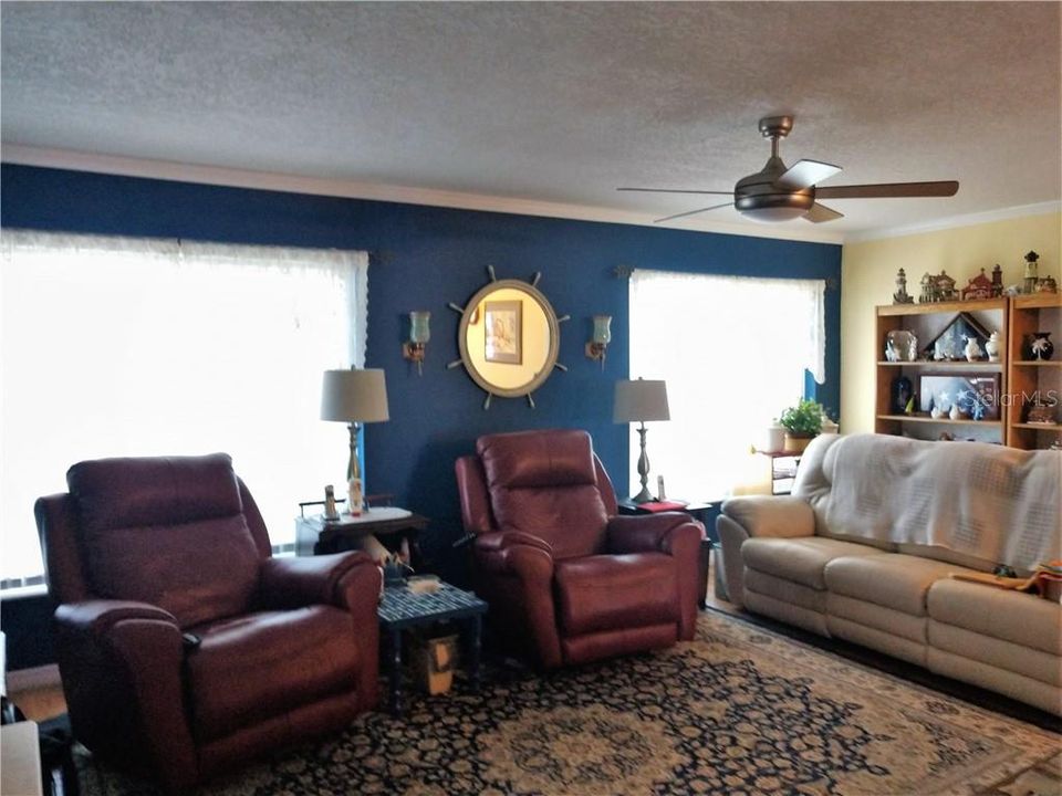 Florida room explodes with natural light.  Other features: crown molding, wood laminate flooring and ceiling fan.