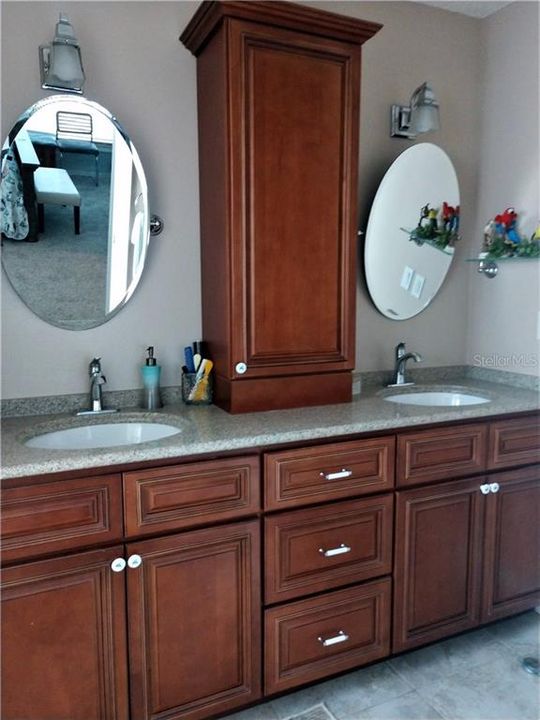 Updated master bath features double sinks, cherry cabinetry that provides lots of storage.