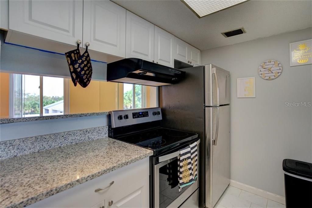 Beautiful granite countertops and stainless steel appliances in the open modern kitchen