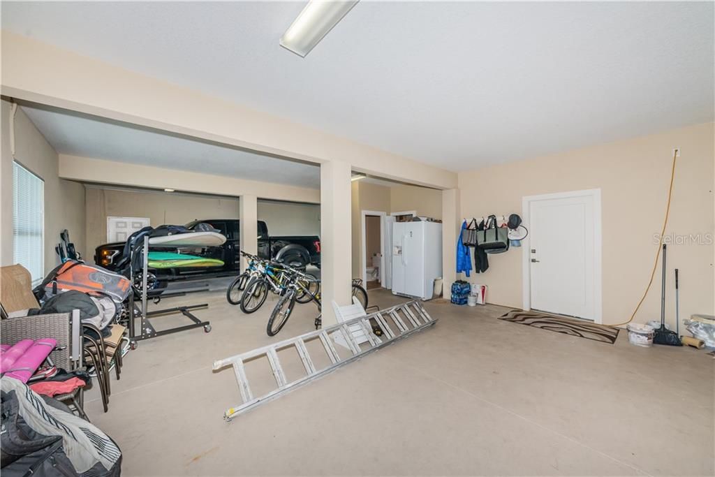 Lower level interior, parking for 3 vehicles, pool bath, and three large storage areas.