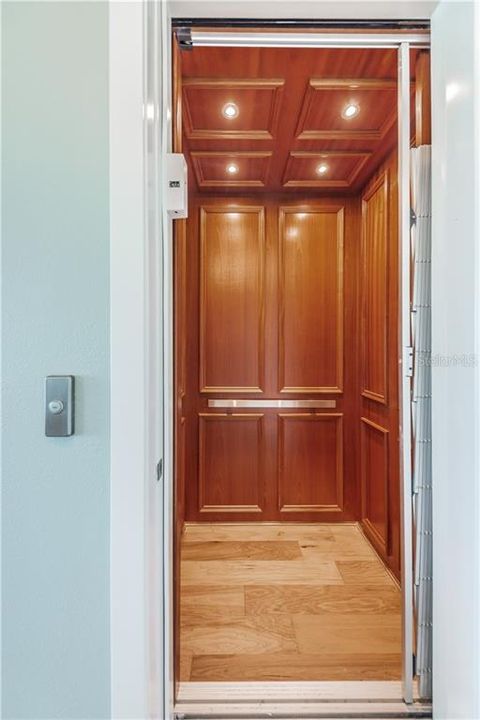 Elevator with elegant wood panel interior.