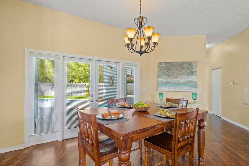 Large dining room with french doors that open out to the pool and private back yard.