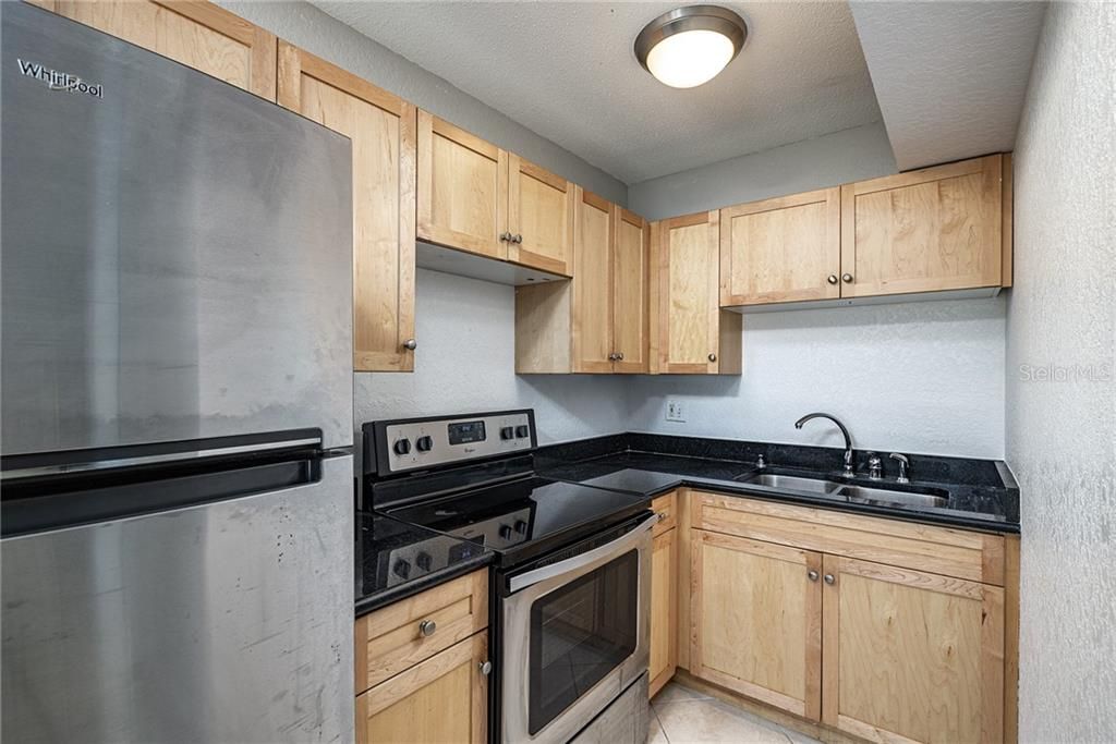 Light wood cabinets, granite counters and stainless steel appliances.