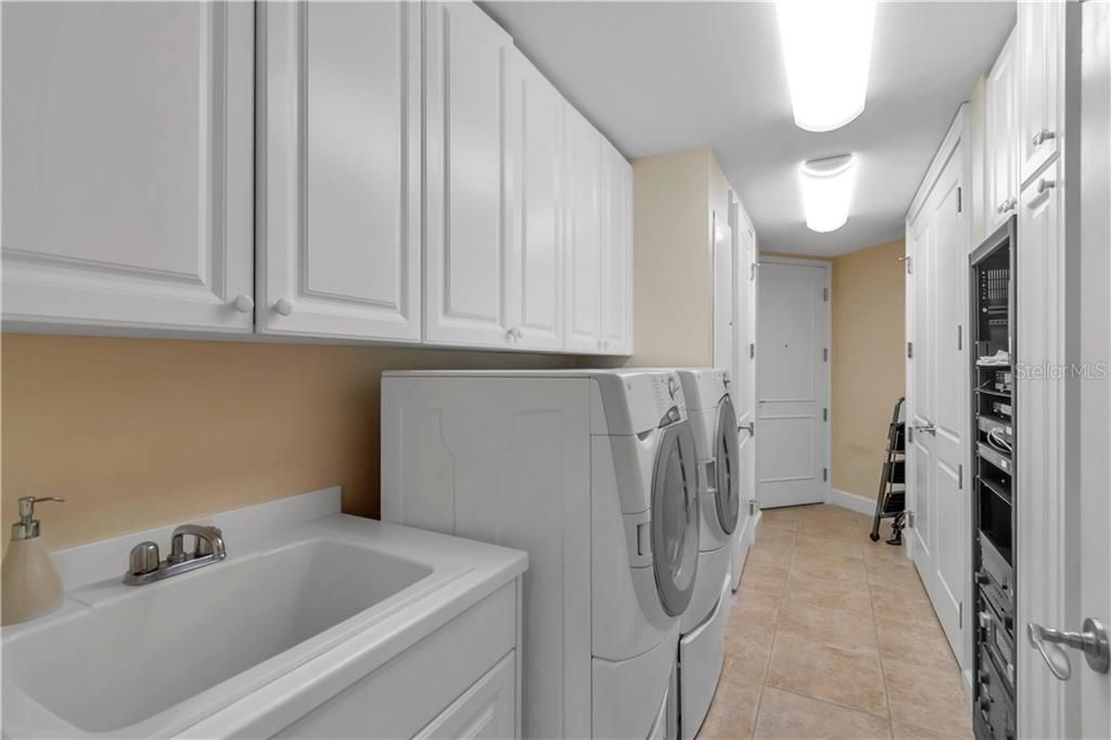 Large laundry with sink, washer and dryer, lots of cabinets !