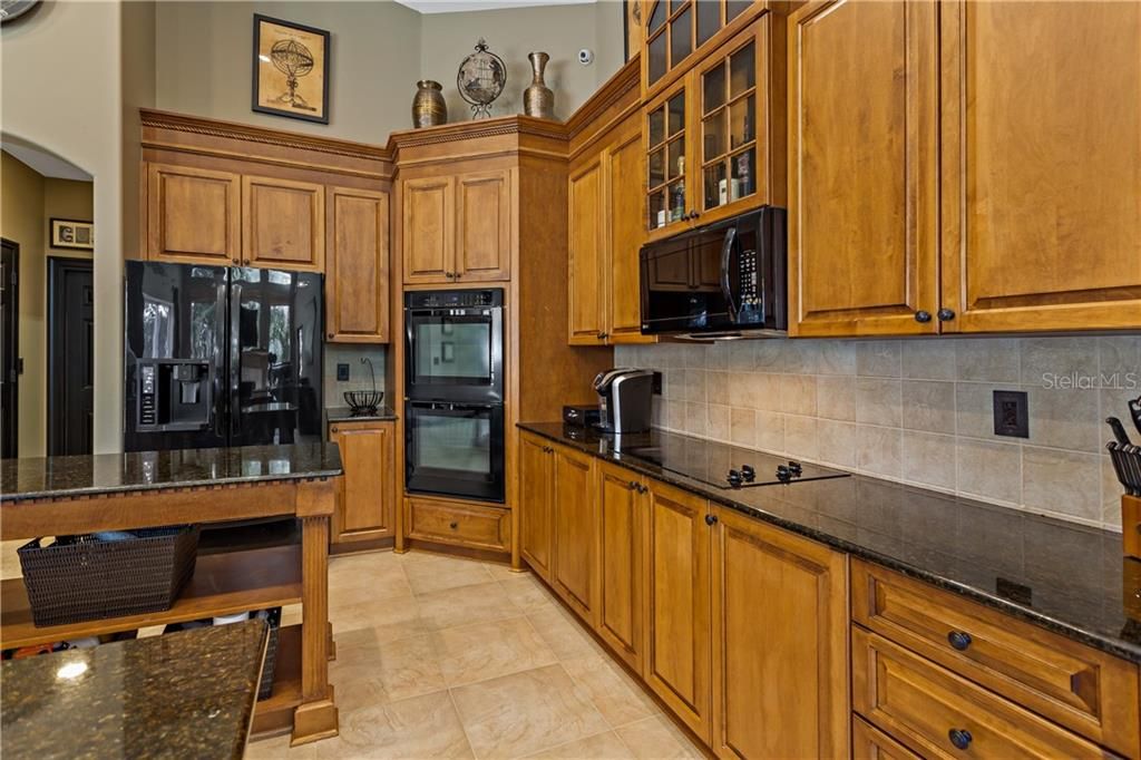 Extra Tall wood cabinets with ornate moldings and granite countertops. Slow stop and some pull out drawers