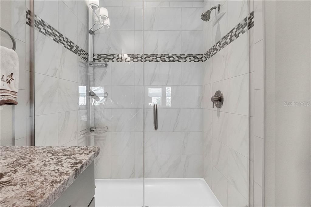 Frameless shower door, decorator wall tile with listello accent.