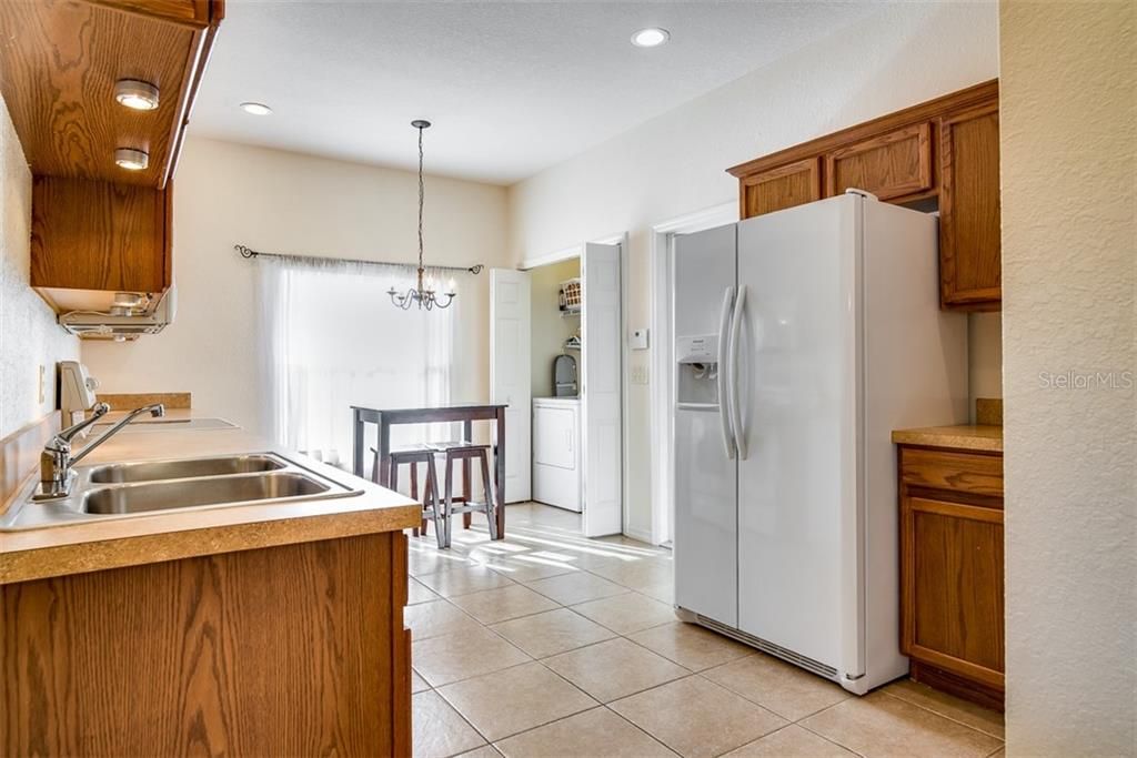 The kitchen features a new refrigerator and oak cabinetry with crown.
