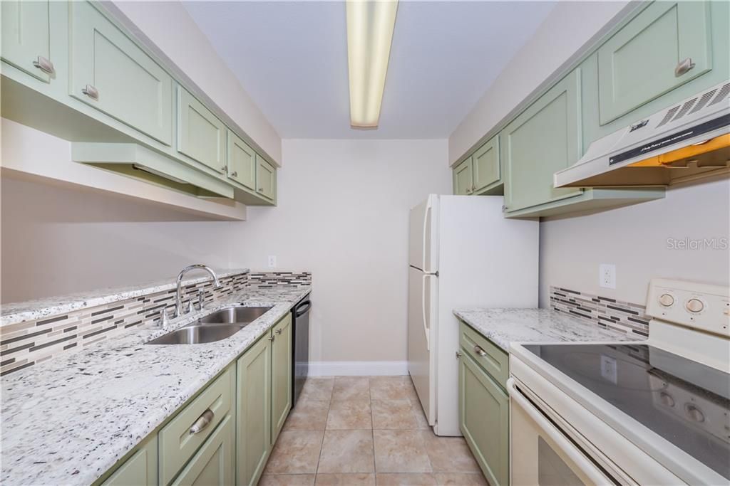 Updated kitchen - cabinets, granite counters, glass backsplash with tile flooring.