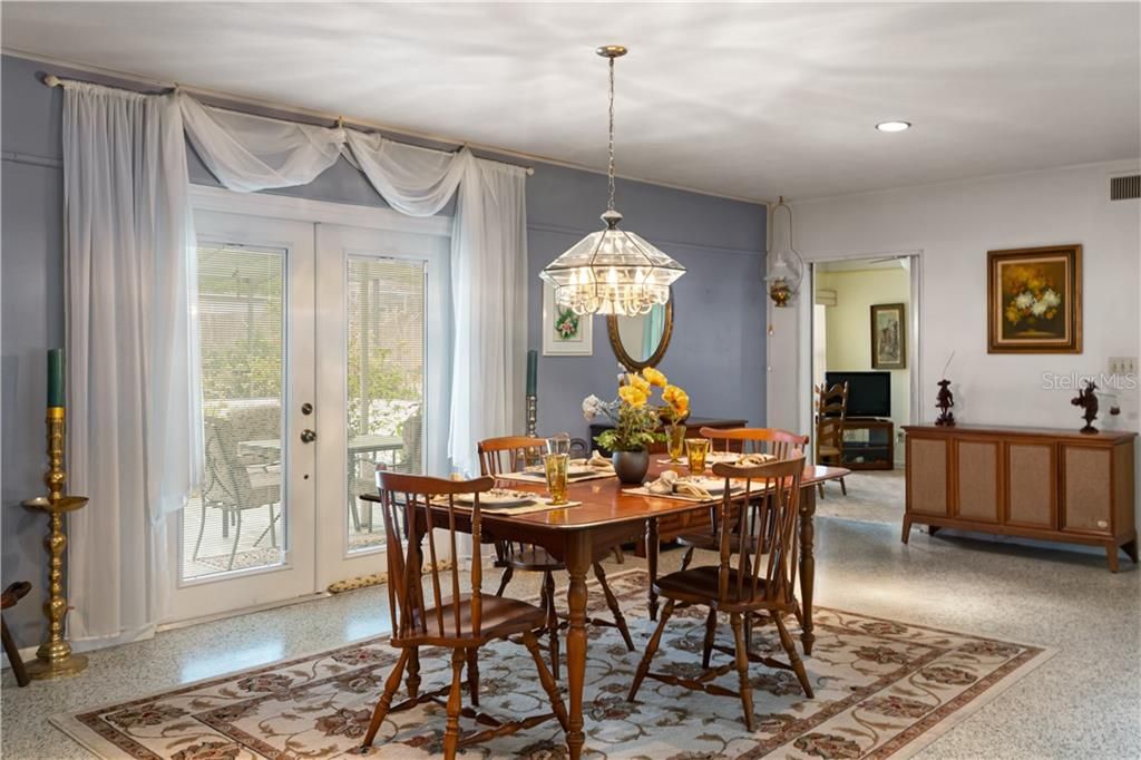 DINING ROOM WITH FRENCH DOORS LEADING TO LANAI AND POOL