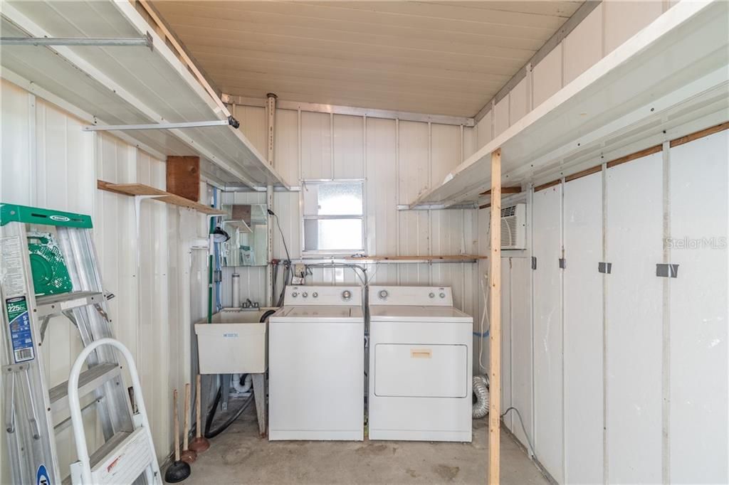 Laundry room with ample storage and wall AC