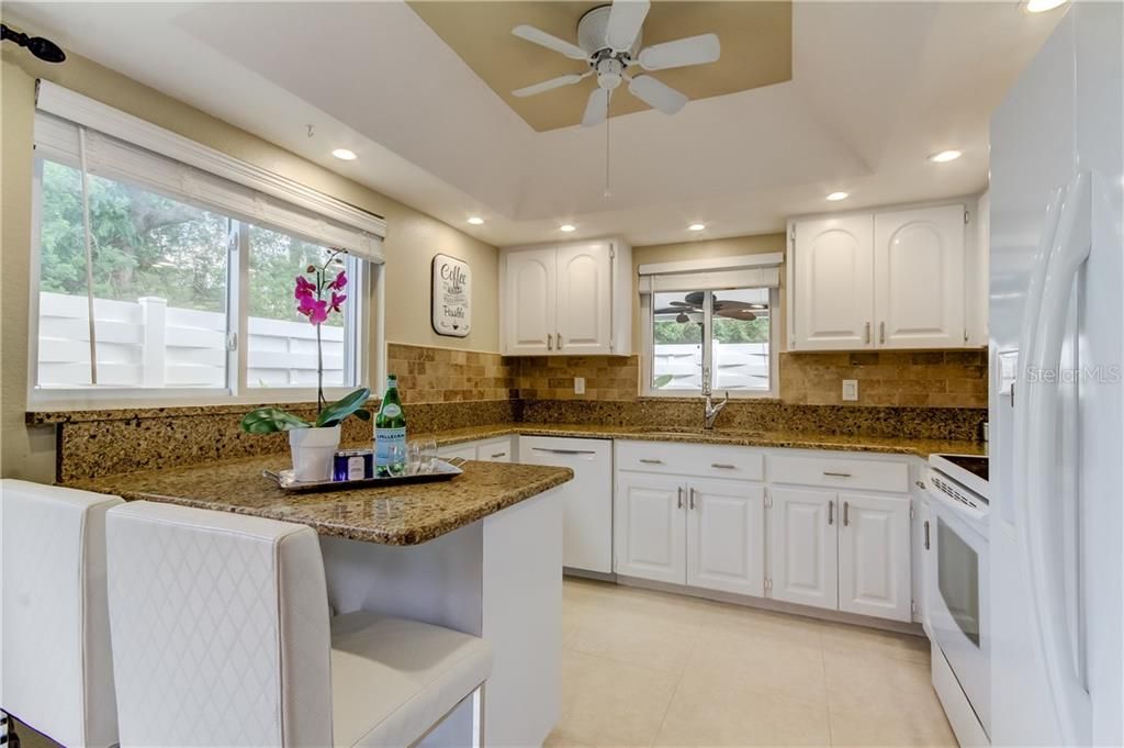 Kitchen with granite counter tops and tile back splash.