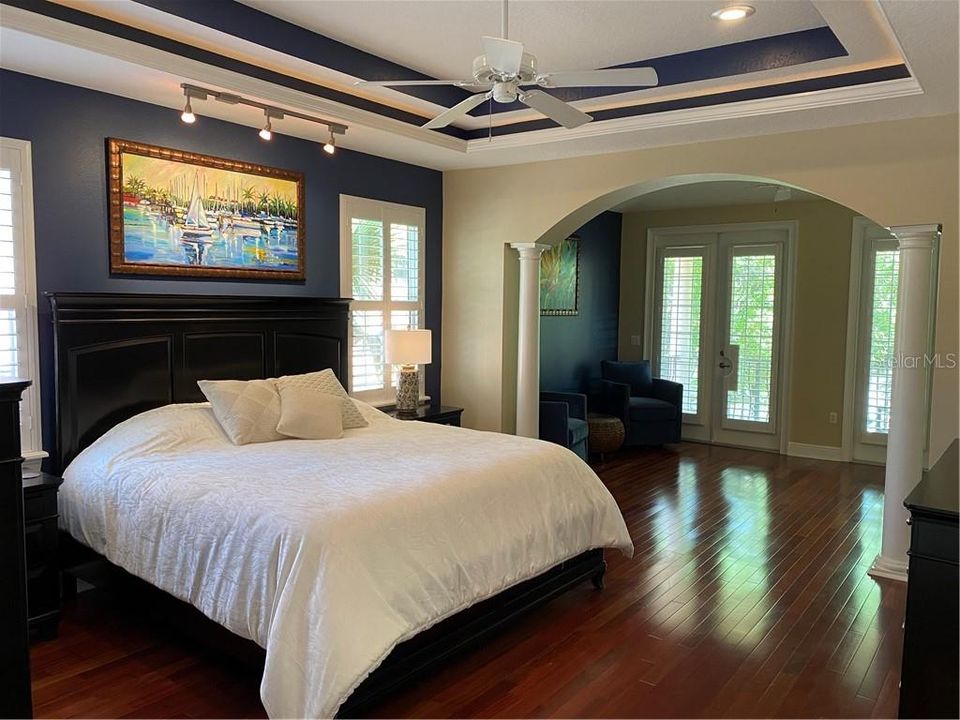 Master bedroom to the sitting room and balcony.  Tray ceiling, wood floors.