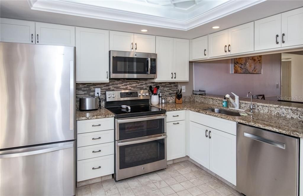 Fabulously updated kitchen with stainless steel applications, a tray ceiling and expansive cabinetry!
