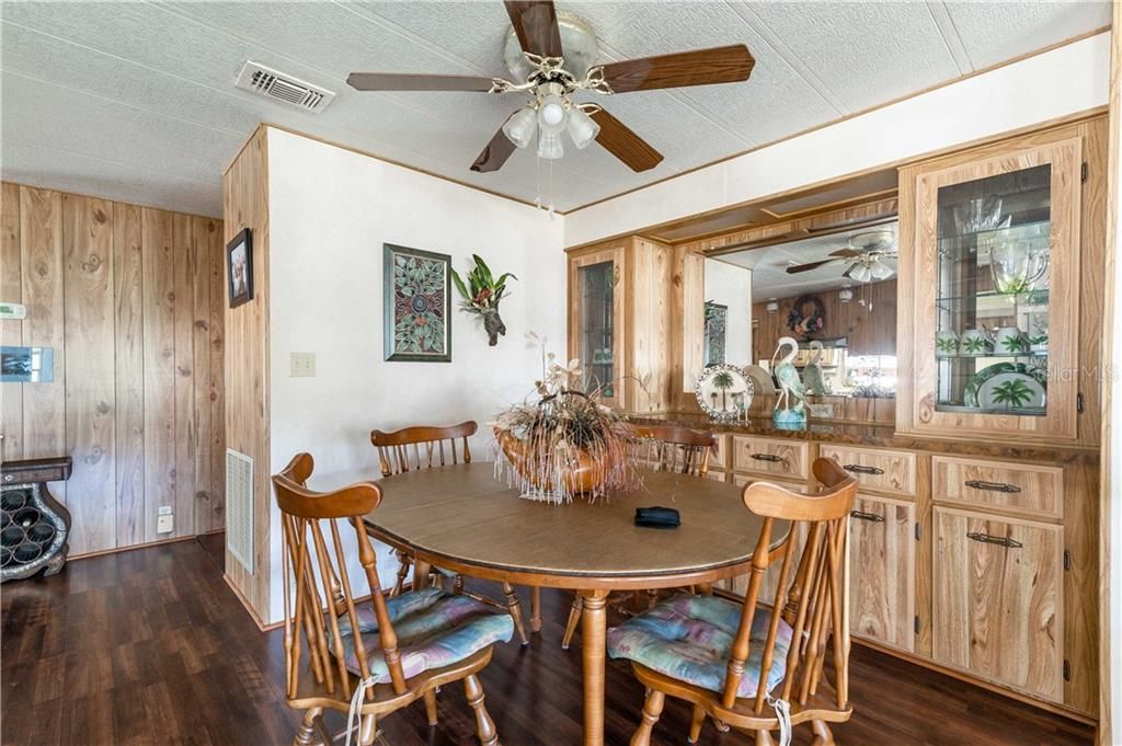 Dining room has built-in storage, ceiling fan, and update laminate flooring.