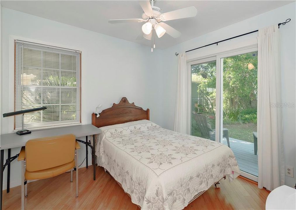Rear bedroom with backyard access and a guests deck, perfect for enjoying your morning coffee.