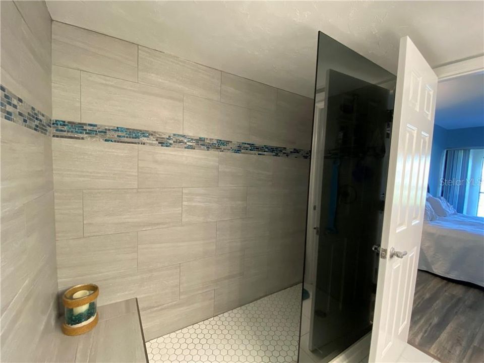 Newly renovated master tile shower with glass wall panel that is water spot resistant!